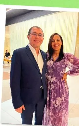 Etniel Anchieta de terno escuro abraçado à esposa, em um evento social.